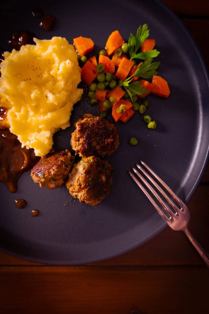 Minifrikadellen mit Kartoffelpüree Zwiebelsoße & Karotten-Erbsen-Gemüse