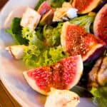 Feigen mit Mozzarella und Pinienkernen auf einem Salatbett