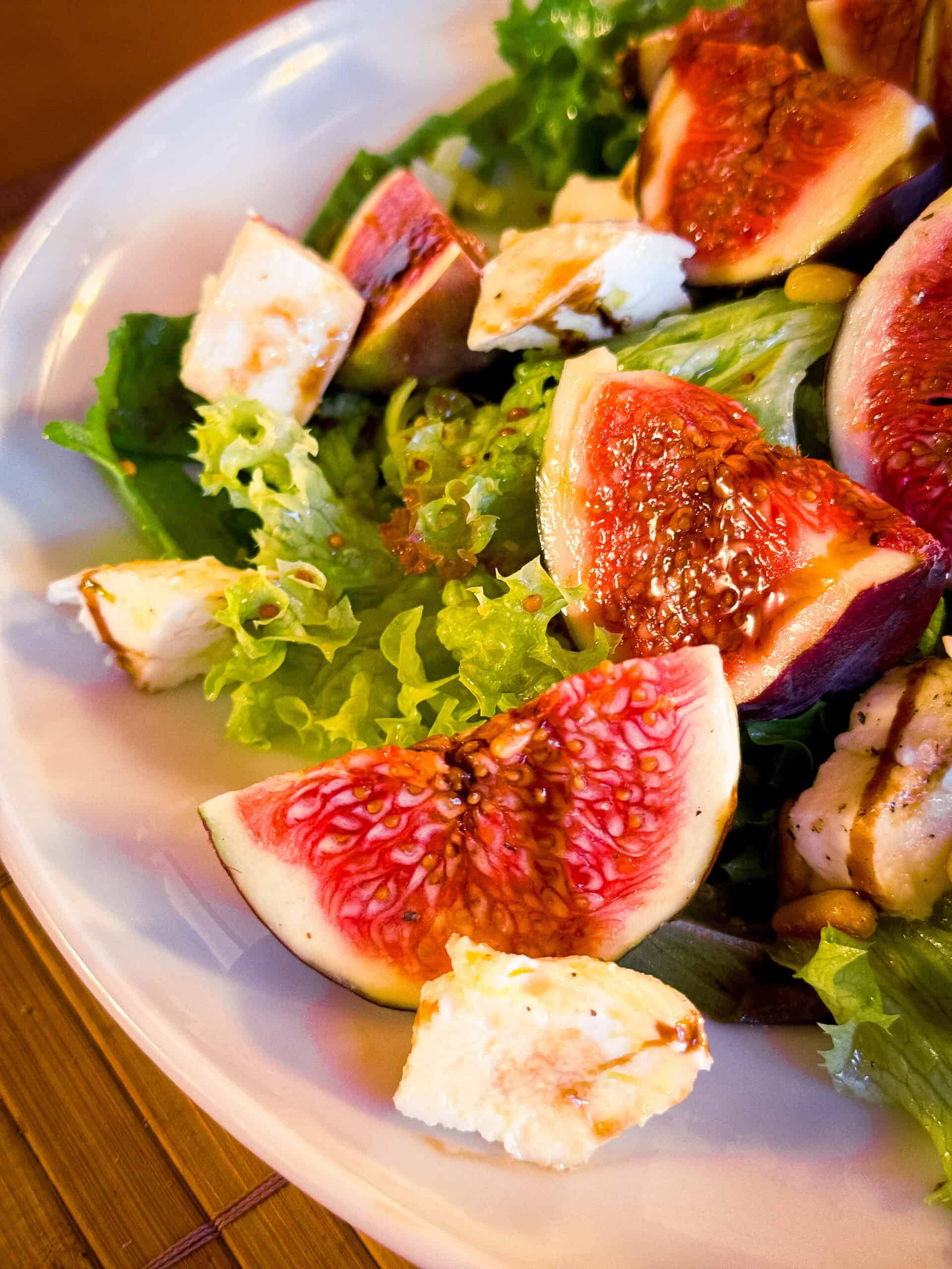 Feigen mit Mozzarella und Pinienkernen auf einem Salatbett